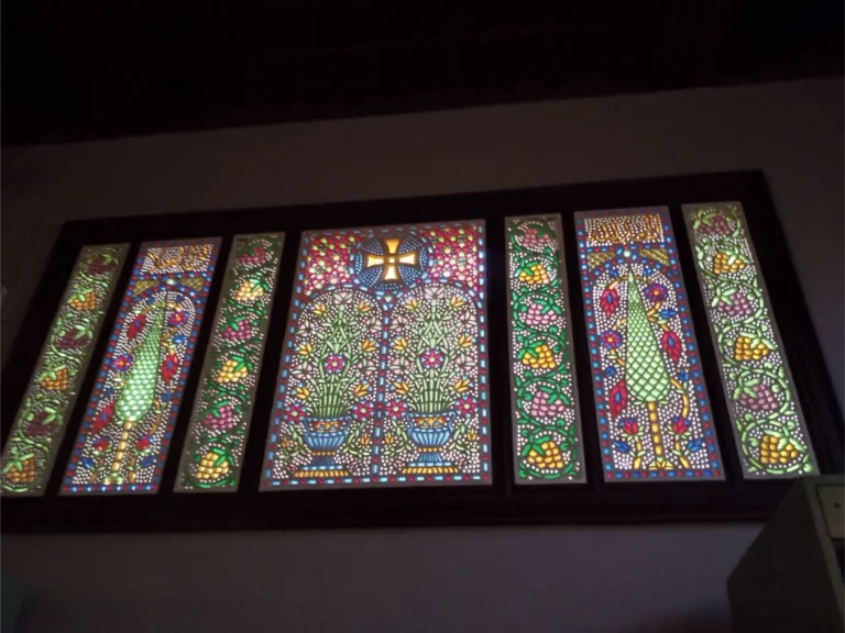 "زجاج معشق ملون داخل المتحف القبطي بالقاهرة، تحفة فنية نادرة تجمع بين الرموز الدينية والزخارف النباتية في لوحة بصرية مبهرة."